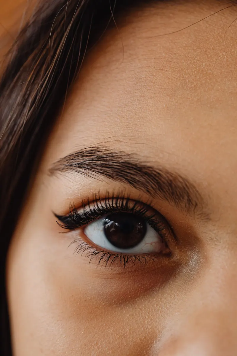 Close-up of an eye with defined lashes and a shaped brow
